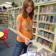 Taylor Robertson, the first participant to complete the Summer Reading Program at the Wiscasset Public Library, deposits her name into the jar. Because she also read a biography, she will place her name in the jar a second time. Three participants who complete the reading requirements of the program have an opportunity to be awarded a Kindle if their names are drawn from the jar. Taylor is the daughter of Tracy Robertson. Courtesy of Wiscasset Public Library