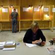 Searsmont Selectman Christopher Staples, background, fills out his ballot on Sept. 17, while Election Moderator and Warden Tammy Roberts passes a quiet moment at the polls. Searsmont was one of two towns to hold votes on withdrawing from Regional School Unit 20 on the same day as an eight-town vote on the district’s budget. (Photo by Ethan Andrews)