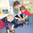 Esme Stucker and her twin sons Maddox and Tiegen collaborate on their picture during a recent Story Time.