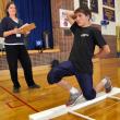 Boothbay Region High School football player Zach Blackman performs one of the movements that make up functional movement screening as LincolnHealth Physical Therapist Heather Brewer watches. The screening is designed to help pinpoint areas of weakness or vulnerability so athletes can avoid injury and perform better. Courtesy of Alan Crowell