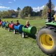 Children took a barrel ride as a tractor pulls them.