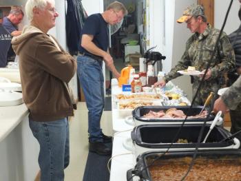 Assistant Chief Roger Whitney makes home fries while fellow volunteer firefighter David Seigers supervises. JOHN MAGUIRE/Wiscasset Newspaper