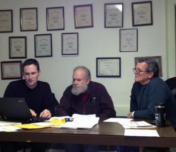 Alna Second Selectman Jonathan Villeneuve, left, First Selectman David Abbott, center, and Third Selectman David Reingardt look at Villeneuve's outline for a possible document to plan and track maintenance and improvements on town-owned buildings. SUSAN JOHNS/Wiscasset Newspaper