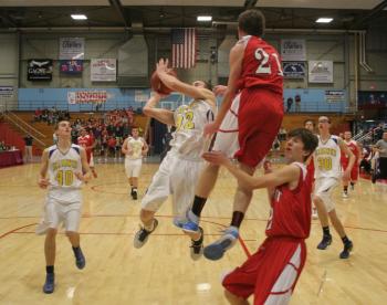 Anthony DiMauro slices through the lane and past the leaping Dale Peaslee to score two of his game-high 19 points. KEVIN BURNHAM/Boothbay Register