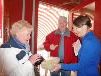 Nancy Gilchrist, right, offers a St. Patrick’s Day cookie to Joyce Tomecko of Rhode Island while John Appleton looks on. KATRINA CLARK/Boothbay Register