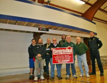 Standing below the YMCA's new scorer's roost are some of the instrumental people in getting the new feature built. From left are, front row: Scott Bennett, Harold Buzzell and Tom Nickerson of Hammond Lumber, Neal Verge; back row: Eddie Crocker, Bill Haney, Jonn Trees and Bob Hasch. KEVIN BURNHAM/Boothbay Register