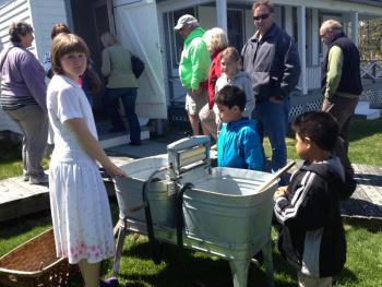 Elizabeth Wright, portraying Prudence Muise, demonstrates how clothes were washed on Burnt Island in 1950. LISA KRISTOFF/Boothbay Register