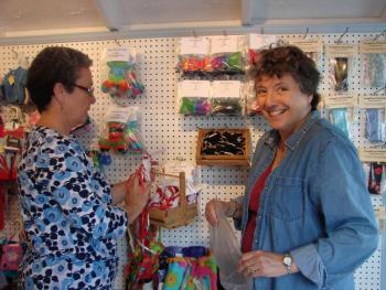 Linda Estabrook, left, and Pam Shockley help set up the Maine Craft Shack on the creamery pier on the waterfront in Wiscasset May 20. Estabrook, Shockley and three other women have a cooperative through which several other crafters' items are also sold. The shack opens Friday, May 24. SUSAN JOHNS/Wiscasset Newspaper