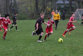 Avery Stewart fends off a Bangor Blackbear as teammates Bayley Gaughan (left) and Simon Spear join him in an offensive bid at Clifford Playground. Midcoast’s U12 team is 2-0-1 for the season. SUE MELLO/Boothbay Register