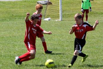 Midcoast United's Wyatt Pinkham gets ready to boot the ball in a game against the Patriots at Clifford Field, Boothbay; team mate Kaleb Ames also pictured in back. SUE MELLO/Boothbay Register