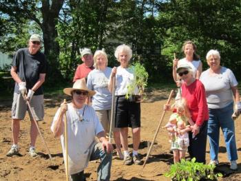 Scott Rittall, front, with help from the volunteers behind him, completed the planting of the community garden at Rittall Farm on Route 27 in Boothbay on June 15. Courtesy of Sarah Foulger