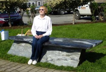 Gloria Taliana sits on the stone memory bench that honors her late husband, Jim Taliana. RYAN LEIGHTON/Boothbay Register