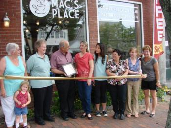 Taking part in a ribbon-cutting on July 1 at Mac's Place are, from left, Wiscasset Selectmen's Vice Chairman Judy Colby with granddaughter Dezirae Colby, Le Garage owner and Wiscasset Area Chamber of Commerce board member Cheryl Rust, Selectmen's Chairman Ed Polewarczyk, Mac's Place owner Karen McDorr, McDorr's daughter Danielle Sylvain, Selectman Pam Dunning, Town Planner Misty Parker and chamber board member Michelle Peele. SUSAN JOHNS/Wiscasset Newspaper