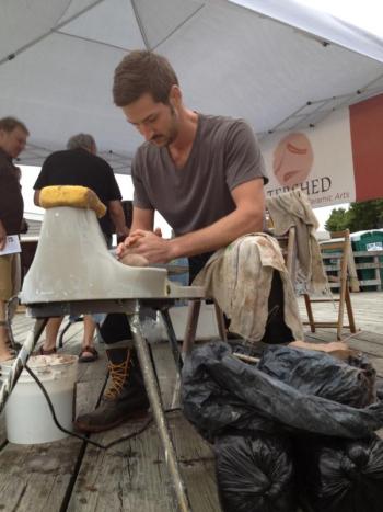 Kirk Jackson of Columbus, Ohio, prepares to throw a cup during the Wiscasset Art Walk August 29. Jackson's wheel demonstration took place at a Watershed Center for the Ceramics Arts tent on the waterfront. SUSAN JOHNS/Wiscasset Newspaper