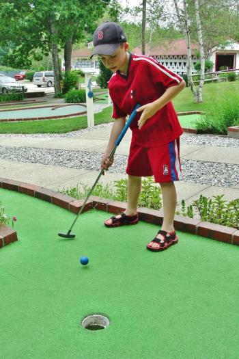 A young boy participates in a previous Maine State Minigolf Open at Dolphin Mini Golf in Boothbay. KEVIN BURNHAM/Boothbay Register