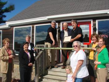 Ribbon-cutting participants at Atlas-Micro September 23 are, clockwise from left, Wiscasset Area Chamber of Commerce board member Patricia Stauble, Wiscasset Selectman Pam Dunning, the chamber board's chairman David Stapp, Atlas-Micro co-owner Enrique Pinero, Selectmen's Chairman Ed Polewarczyk, the business' co-owner Harry DeLoe, chamber board member Monique McRae, Town Planner Misty Parker, Selectman Judy Colby, and Colby's granddaughter Desirae Colby, 3. SUSAN JOHNS/Wiscasset Newspaper