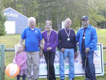 The top four finishers. Accompanied by tournament “mascot,”Addie Barter, left, the top four finishers of the 20th annual Dolphin Mini Golf Open stand together after the tournament. From left are Lee Stoddard (fourth), Nancy Gilchrist (third), Peter Gilchrist (second) and Joshua Tiberio (first). Courtesy of Lee Stoddard