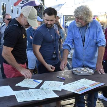 Three men judge the shucking contest. 