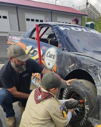 Peter Kolbe and Arrow of Light Scout Jereimiah Raposa change a tire. Courtesy photo 