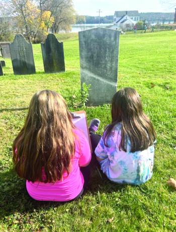 Brooklyn Jusseaume and Amelia Gamrat take notes at a gravestone. Emma Rossignol photo