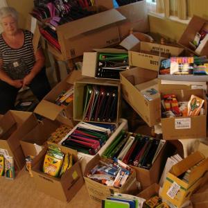 Shown partly surrounded by donated school supplies, Sue Burge is determined to help all students at three area elementary schools start the next school year right. SUSAN JOHNS/Wiscasset Newspaper