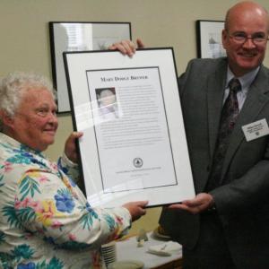 Mary Brewer receives the plaque honoring her as a 2012 inductee into the Maine Press Association's Hall of Fame from Mike Dowd, president of the MPA, at the ceremony held at the Hilton Garden Inn in Freeport October 13. SARAH MORLEY/Boothbay Register