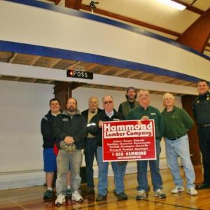 Standing below the YMCA's new scorer's roost are some of the instrumental people in getting the new feature built. From left are, front row: Scott Bennett, Harold Buzzell and Tom Nickerson of Hammond Lumber, Neal Verge; back row: Eddie Crocker, Bill Haney, Jonn Trees and Bob Hasch. KEVIN BURNHAM/Boothbay Register