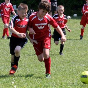 Grady Schur battles for the ball during the June 2 game against the Patriots at Clifford Playground, which ended in a 1-1 tie. Also pictured are Midcoast teammates Kaleb Ames, right, and Sam Sinibaldi, left. SUE MELLO/Boothbay Register