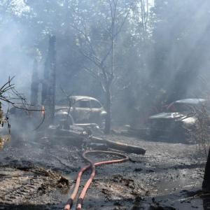 Dissipating hose mist reveals vehicles singed by flames from a barn fire at 207 Ludwig Road, in Hope, Wednesday, Sept. 11, 2024. (Photo by Sarah Thompson)