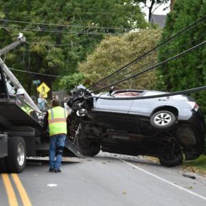 A car is loaded onto a wrecker after toppling a utility pole on Washington Street. (Photo by Sarah Thompson)