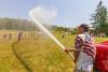 Rob Hopkins uses the fire hose to cool off the kids on Squirrel Island. Courtesy of Mike Leonard