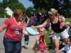 Wiscasset Town Manager Laurie Smith, left, walks Hooper Street offering July 4 schedules just prior to the start of the parade. Taking one is Shawna Roy of Wiscasset. SUSAN JOHNS/Wiscasset Newspaper