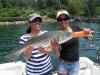 Trudi Barry of Fort Lauderdale, Fla., left, and Edelisse Rivera of Miami, Fla. hold a 28-inch bass (10.8 pounds) that they caught and released while fishing with Steve and Chris Rubicam on July 24. They are both recent University of Florida School of Nursing grads, now RN's and working in Maine for the summer. Courtesy of Steve Rubicam